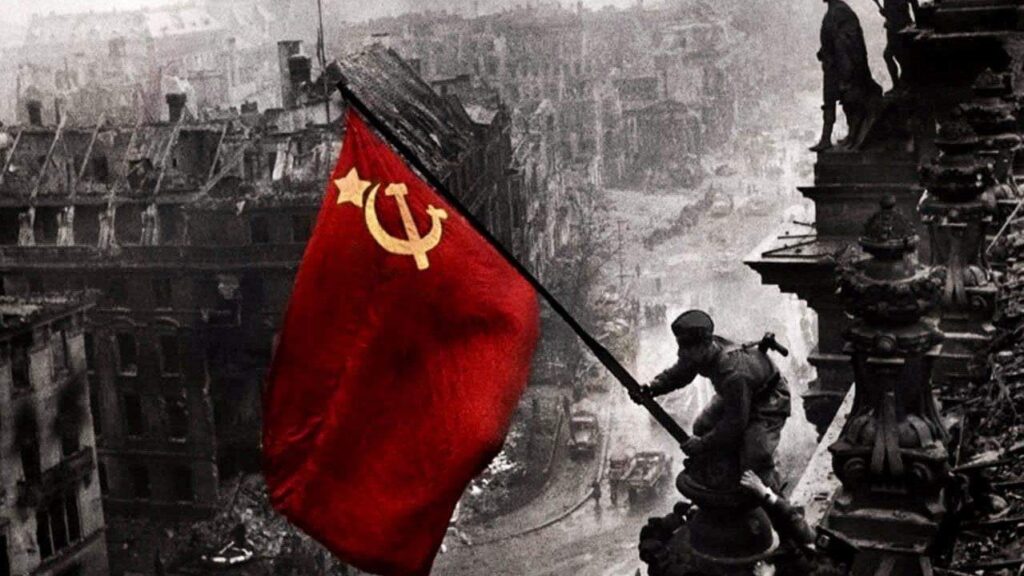 80 anos do Dia da Vitória e os símbolos em disputa 1 80-anos-do-dia-da-vitoria-e-os-simbolos-em-disputa-a-iconica-foto-icando-uma-bandeira-sobre-o-reichstag-ilustracao-sobre-foto-que-mostra-a-bandeira-sovietica-urss-icada-no-predio-do-parlamento-alemao-foto-yevgeny-khaldei-tvt-news