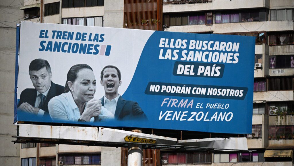 nao-foi-o-trump-corina-machado-ganha-premio-nobel-da-paz-um-outdoor-em-caracas-diz-que-os-lideres-da-oposicao-da-esquerda-para-a-direita-leopoldo-lopez-maria-corina-machado-e-juan-guaido-sao-responsaveis-pelas-sancoes-impostas-pelos-eua-a-venezuela-foto-federico-parra-afp-tvt-news