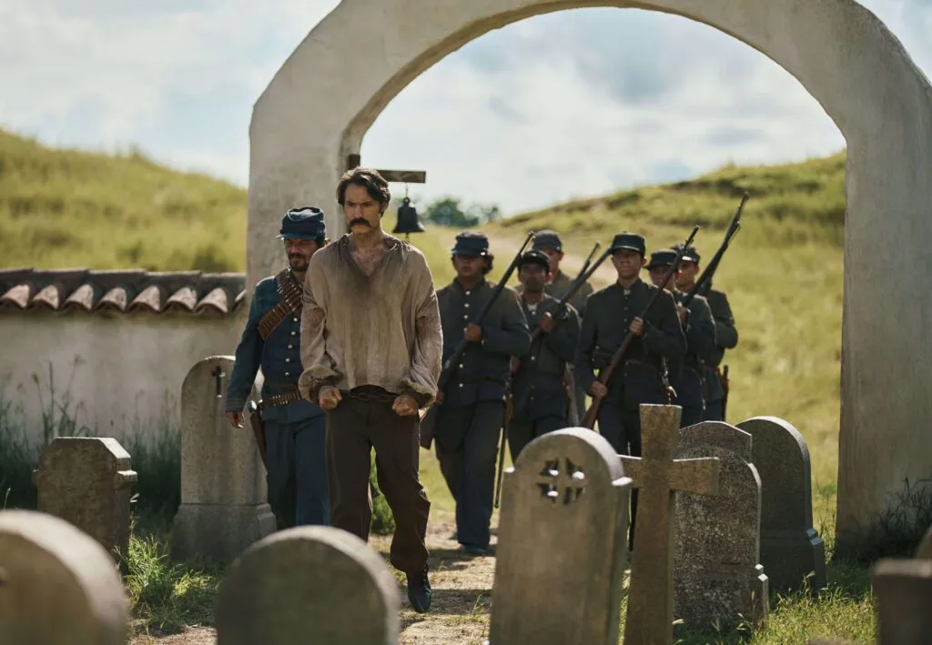 Cem Anos de Solidão é história da América Latina 2 cem-anos-de-solidao-netflix-muitos-anos-depois-diante-do-pelotao-de-fuzilamento-o-coronel-aureliano-buendia-haveria-de-recordar-aquela-tarde-remota-em-que-seu-pai-o-levou-para-conhecer-o-gelo-foto-mauro-gonzalez-netflix-2024-tvt-news
